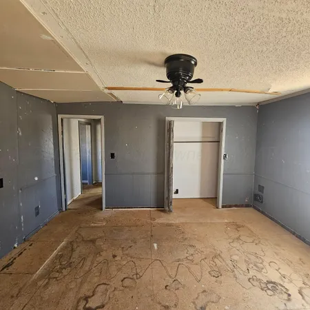 a view of a livingroom with a chandelier fan and a kitchen