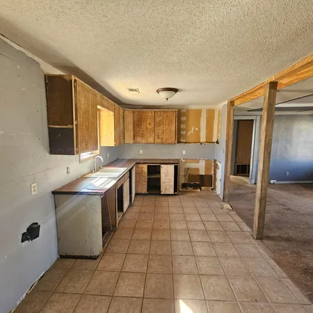 a large kitchen with a stove a refrigerator and a sink