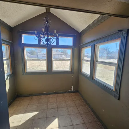 an empty room with windows and chandelier