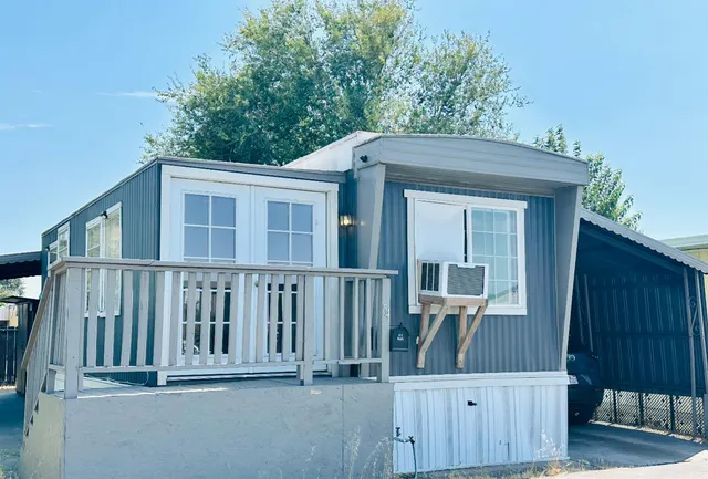 a view of a house with a small yard and wooden fence