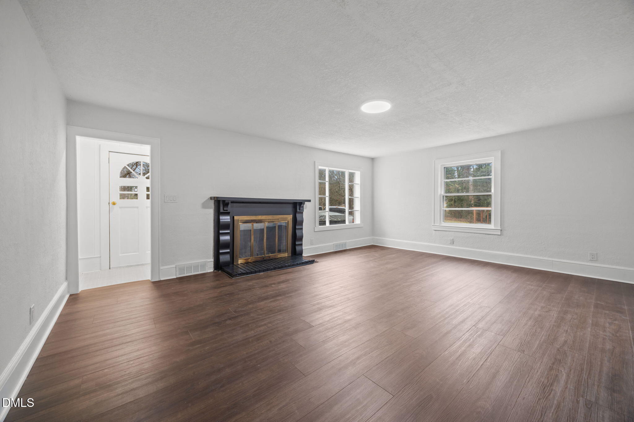 1811 Lazy Lane High Point, NC 27265 - Photo 10 of 44 an empty room with wooden floor fireplace and windows