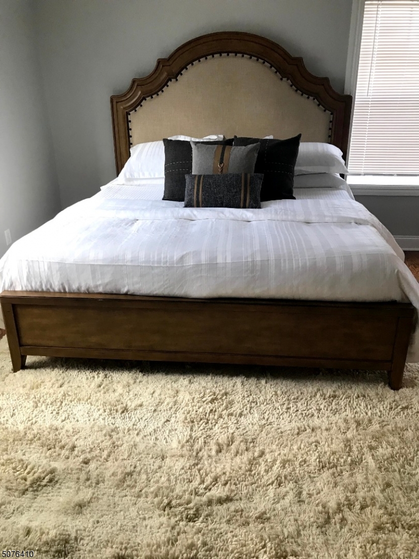 569 Springfield Avenue, Unit 5 Berkeley Heights, NJ 07922 - Photo 6 of 12 a bed sitting in a bedroom next to a window