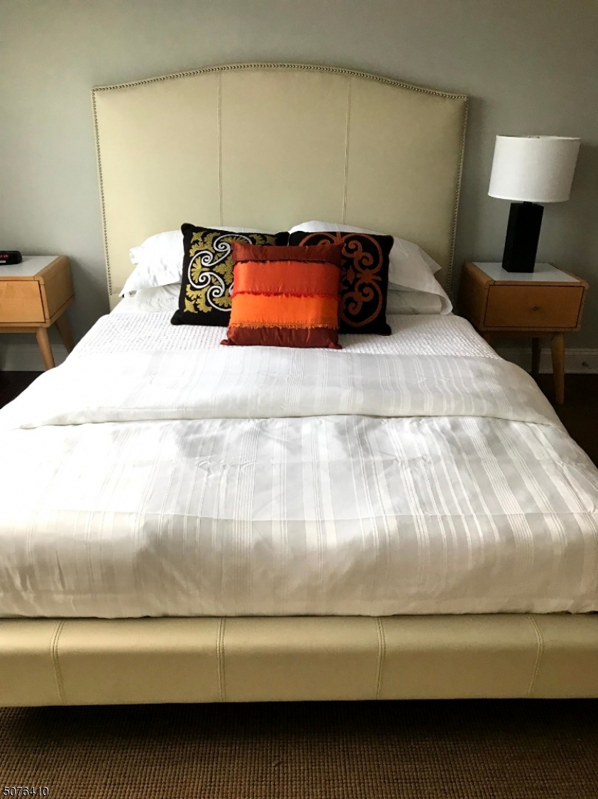 569 Springfield Avenue, Unit 5 Berkeley Heights, NJ 07922 - Photo 8 of 12 a bedroom with a bed and lamp