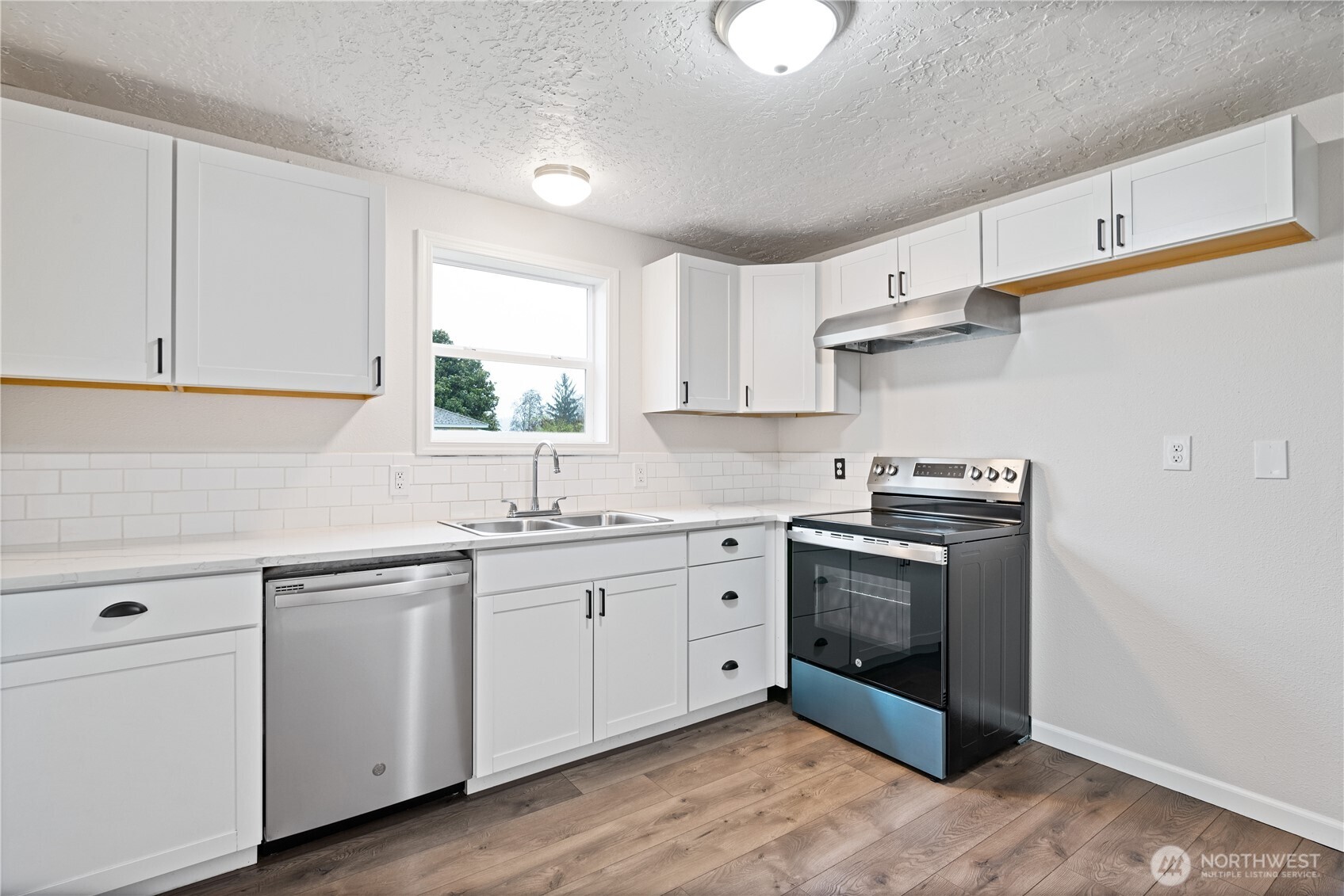 316 15th Avenue Longview, WA 98632 - Photo 11 of 30 a kitchen with stainless steel appliances granite countertop a sink and cabinets with wooden floors