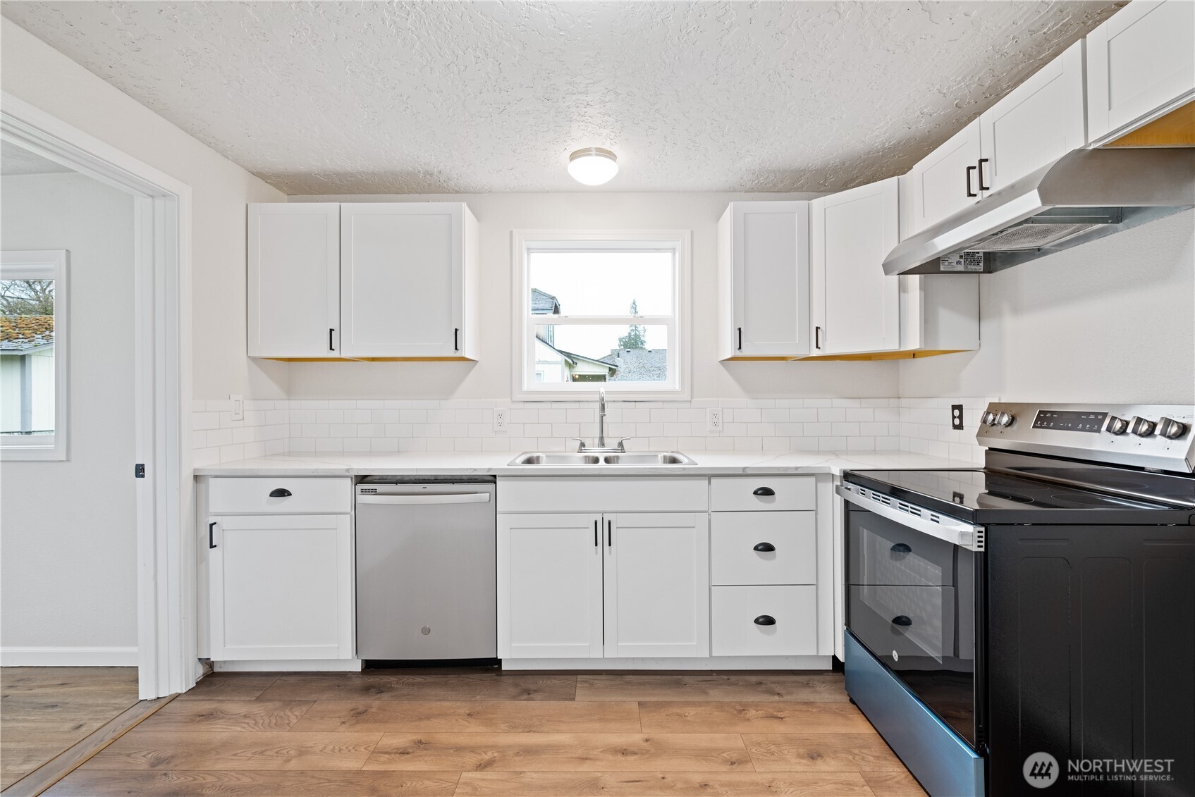 316 15th Avenue Longview, WA 98632 - Photo 13 of 30 a kitchen with cabinets appliances a sink and a window