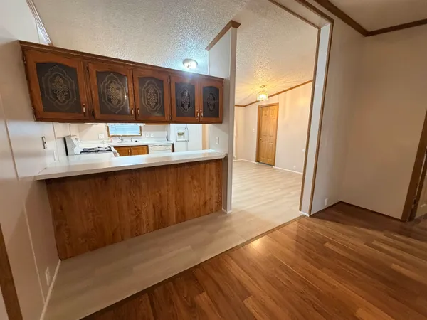 a kitchen with stainless steel appliances granite countertop a sink and cabinets with wooden floor