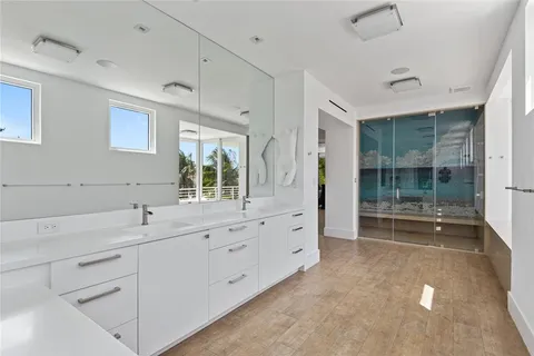 a bathroom with a sink mirror and shower
