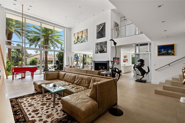 a living room with furniture a fireplace and a large window