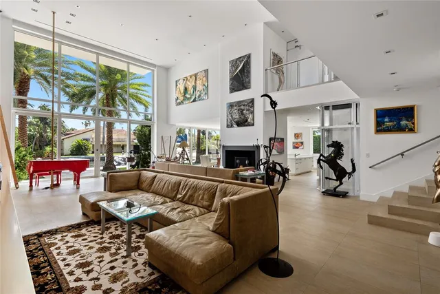 a living room with furniture a fireplace and a large window