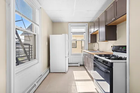 a kitchen with a stove a refrigerator and a stove top oven