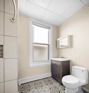 a white toilet sitting next to a bathroom sink vanity and tub
