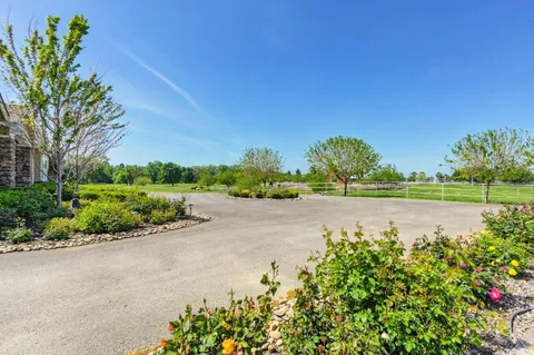 a backyard of a house with lots of green space and fountain
