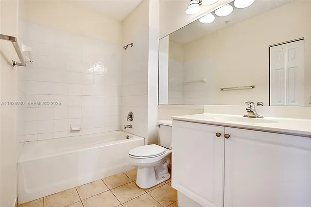 a bathroom with a bathtub shower sink vanity mirror and toilet
