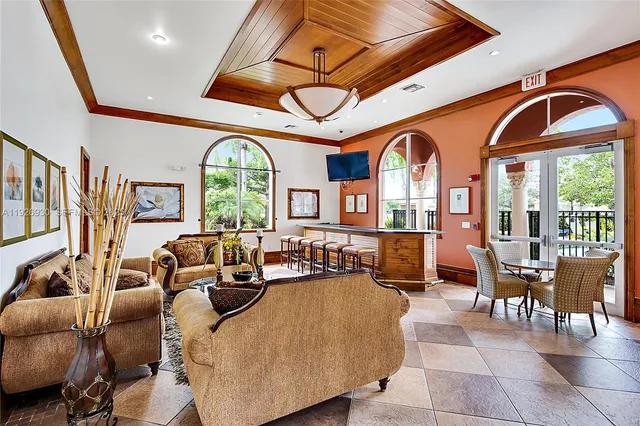 a living room with furniture a fireplace and large windows