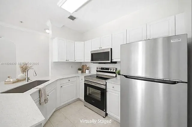 a kitchen with stainless steel appliances a refrigerator sink and microwave