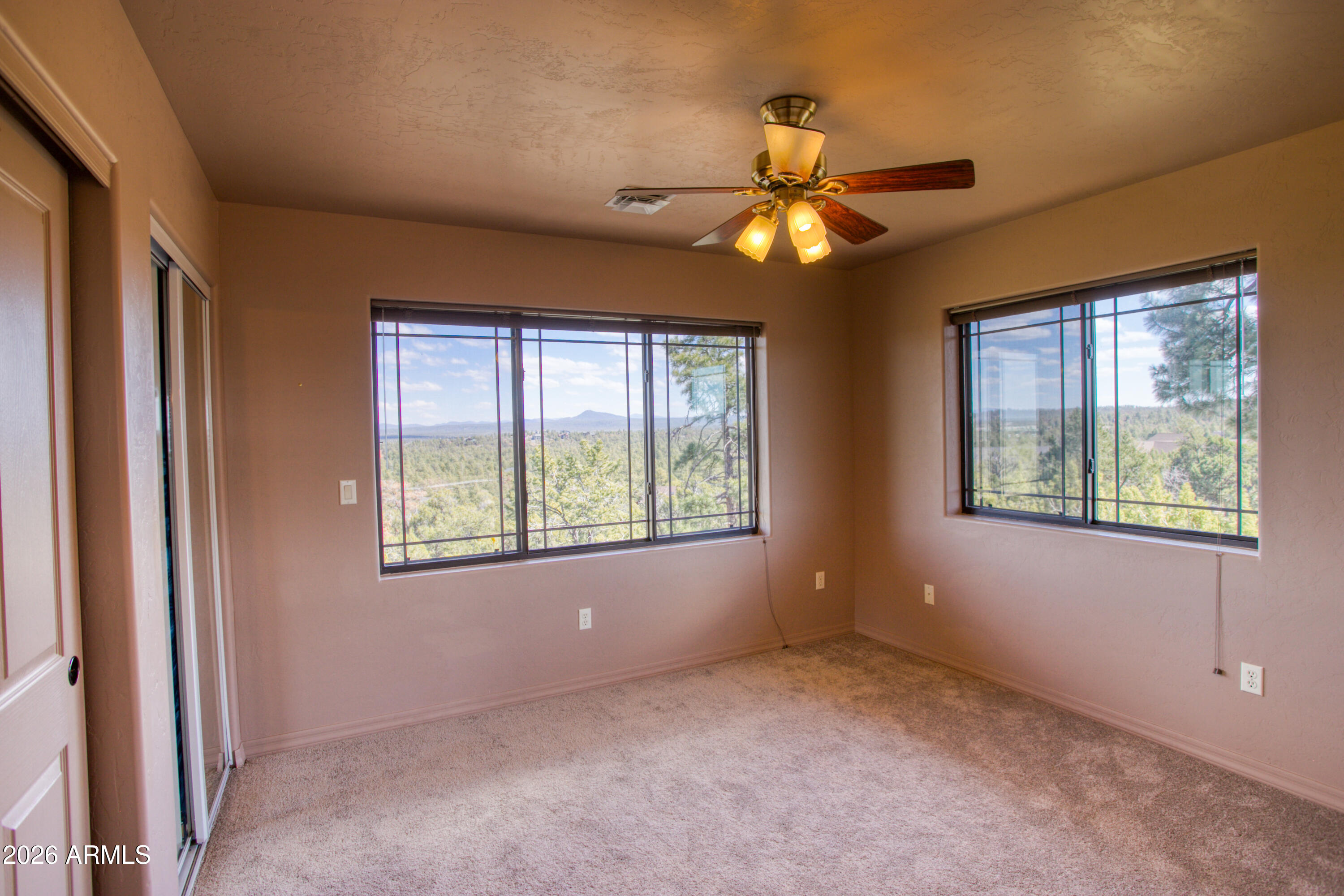 1511 South Canyon Ridge Trail Show Low, AZ 85901 - Photo 31 of 61 a view of an empty room with windows and chandelier fan