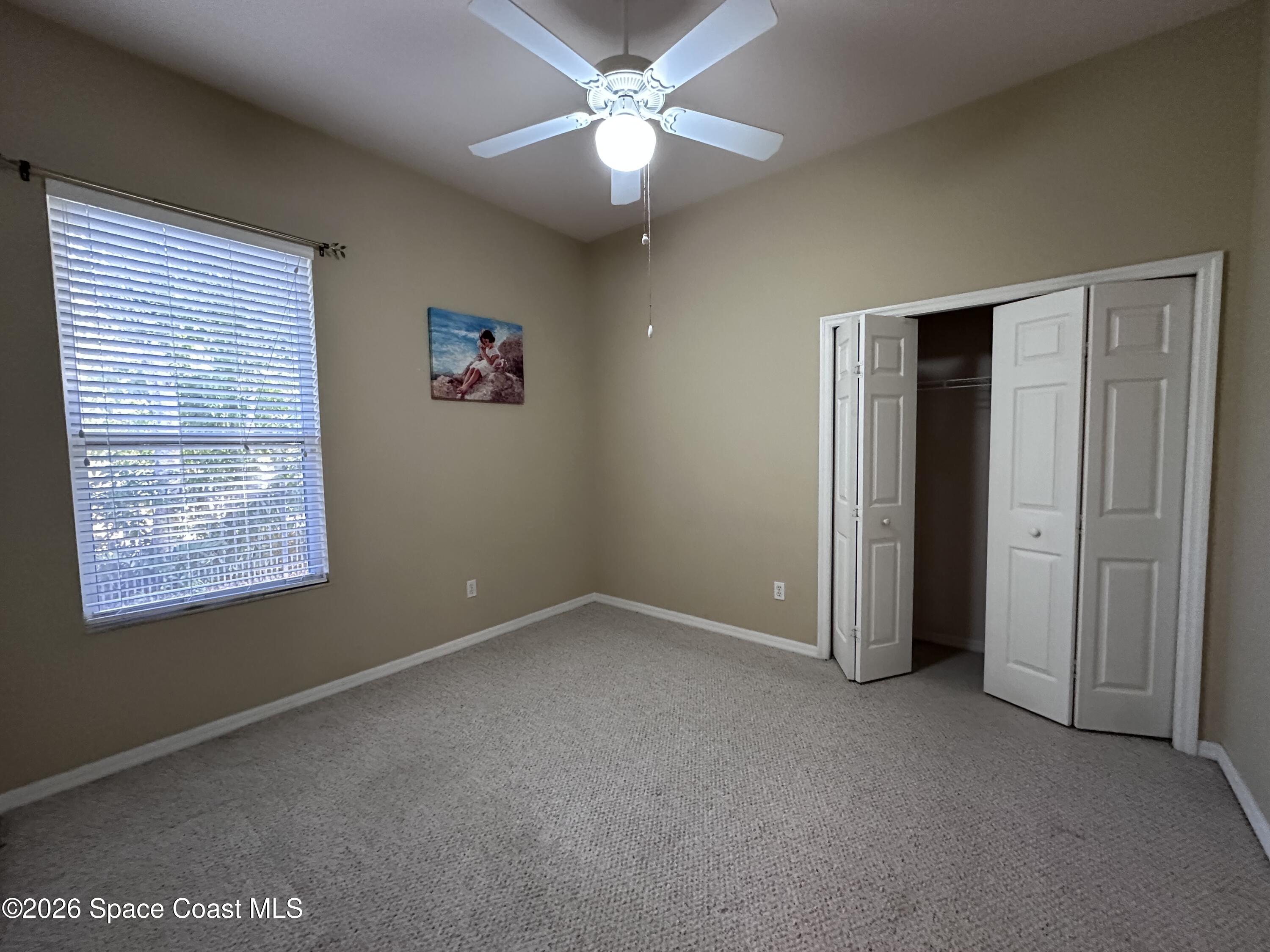 883 Spring Oak Drive Melbourne, FL 32901 - Photo 14 of 43 an empty room with a window and a fan