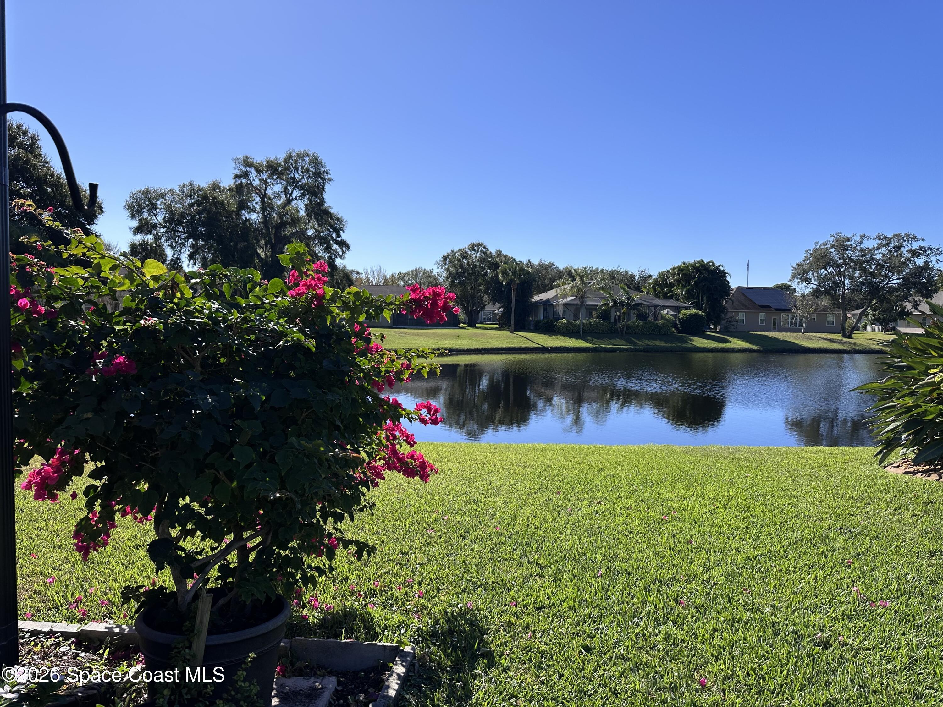 883 Spring Oak Drive Melbourne, FL 32901 - Photo 17 of 43 a view of a lake with a house in the background