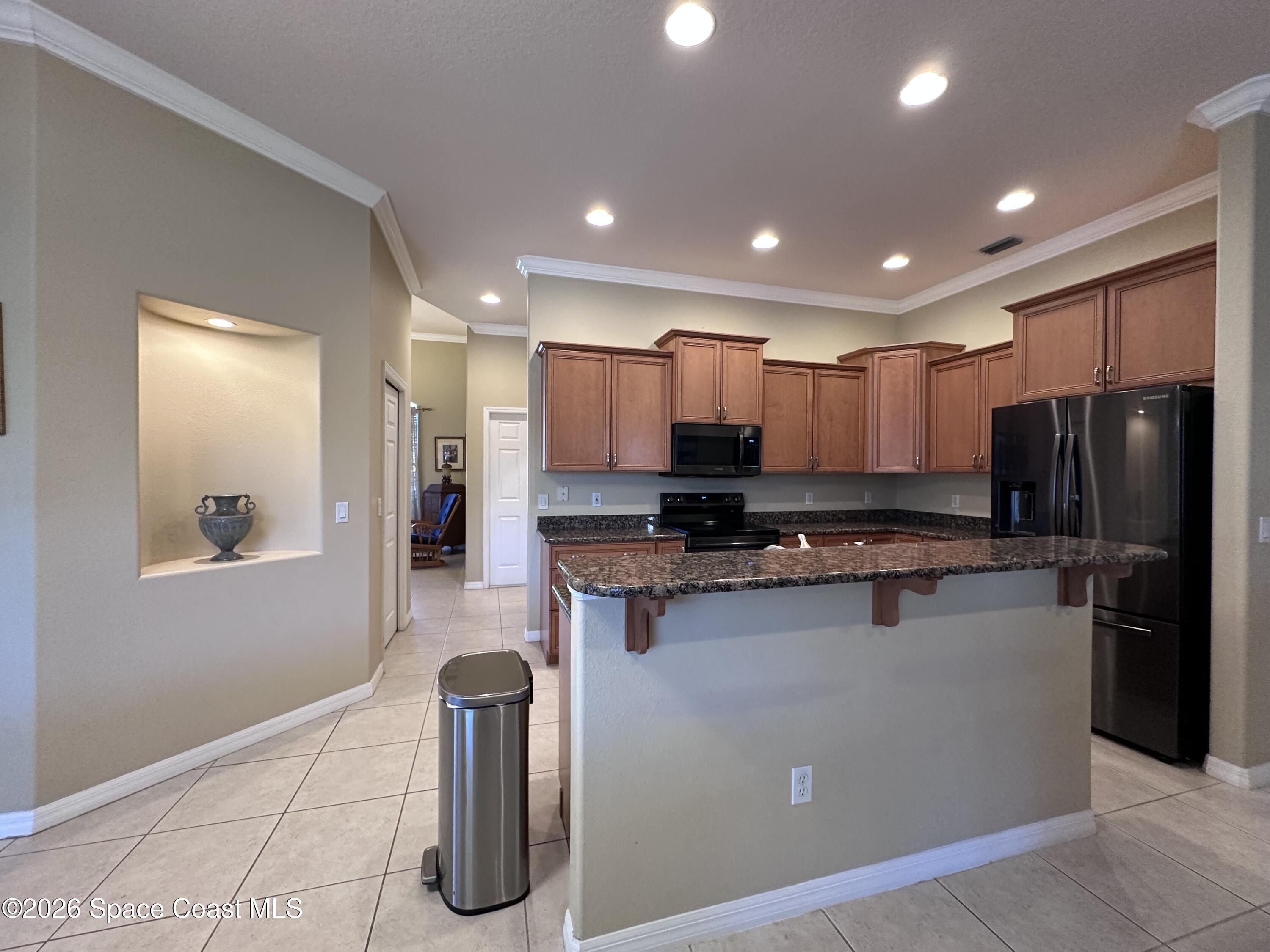 883 Spring Oak Drive Melbourne, FL 32901 - Photo 20 of 43 a kitchen with stainless steel appliances granite countertop a refrigerator sink and stove