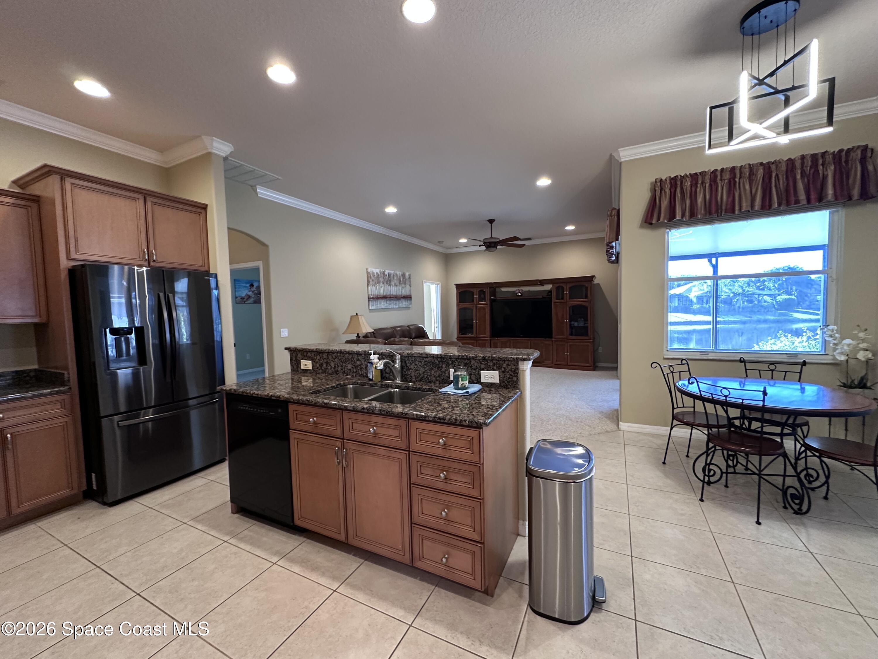 883 Spring Oak Drive Melbourne, FL 32901 - Photo 21 of 43 a kitchen with stainless steel appliances granite countertop a sink and a refrigerator