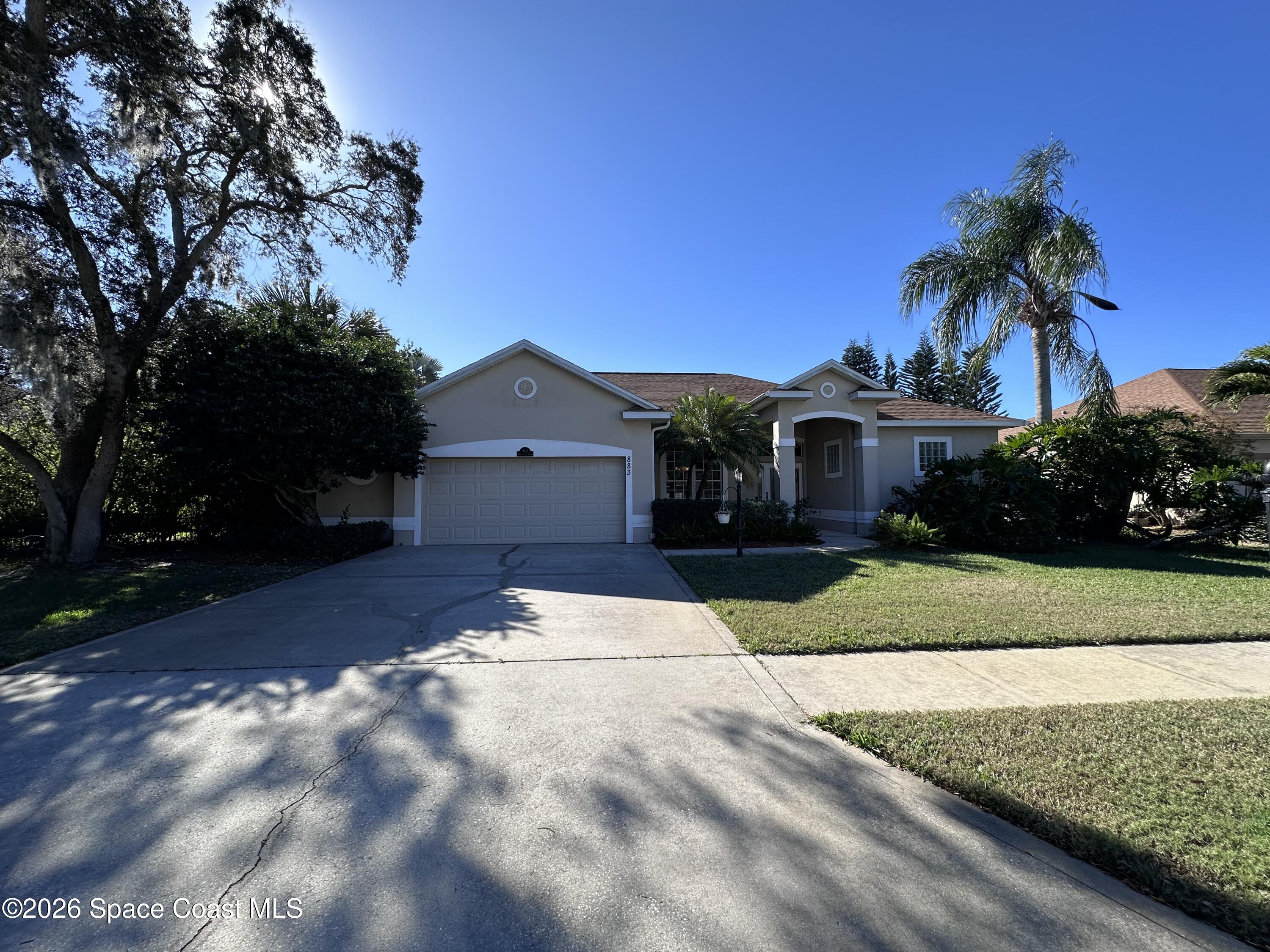 883 Spring Oak Drive Melbourne, FL 32901 - Photo 33 of 43 a front view of a house with a yard and palm tree