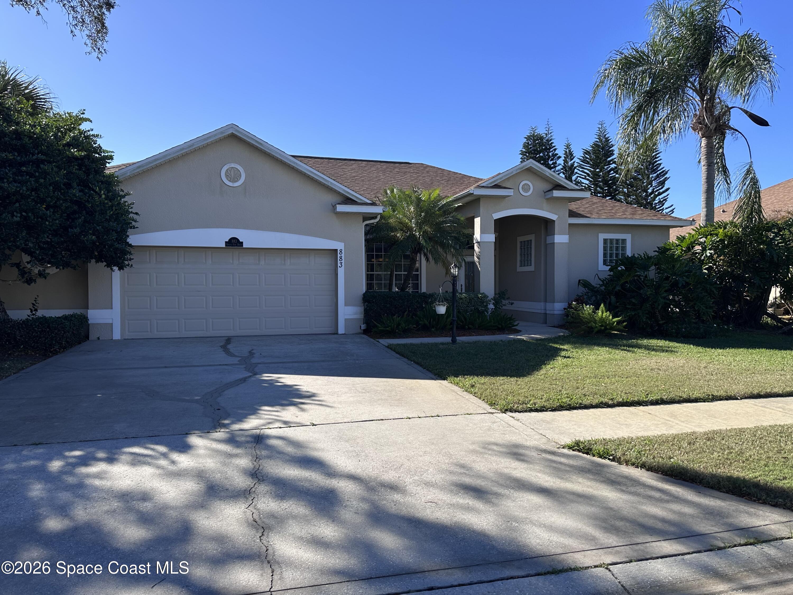 883 Spring Oak Drive Melbourne, FL 32901 - Photo 35 of 43 a front view of a house with a yard and a garage