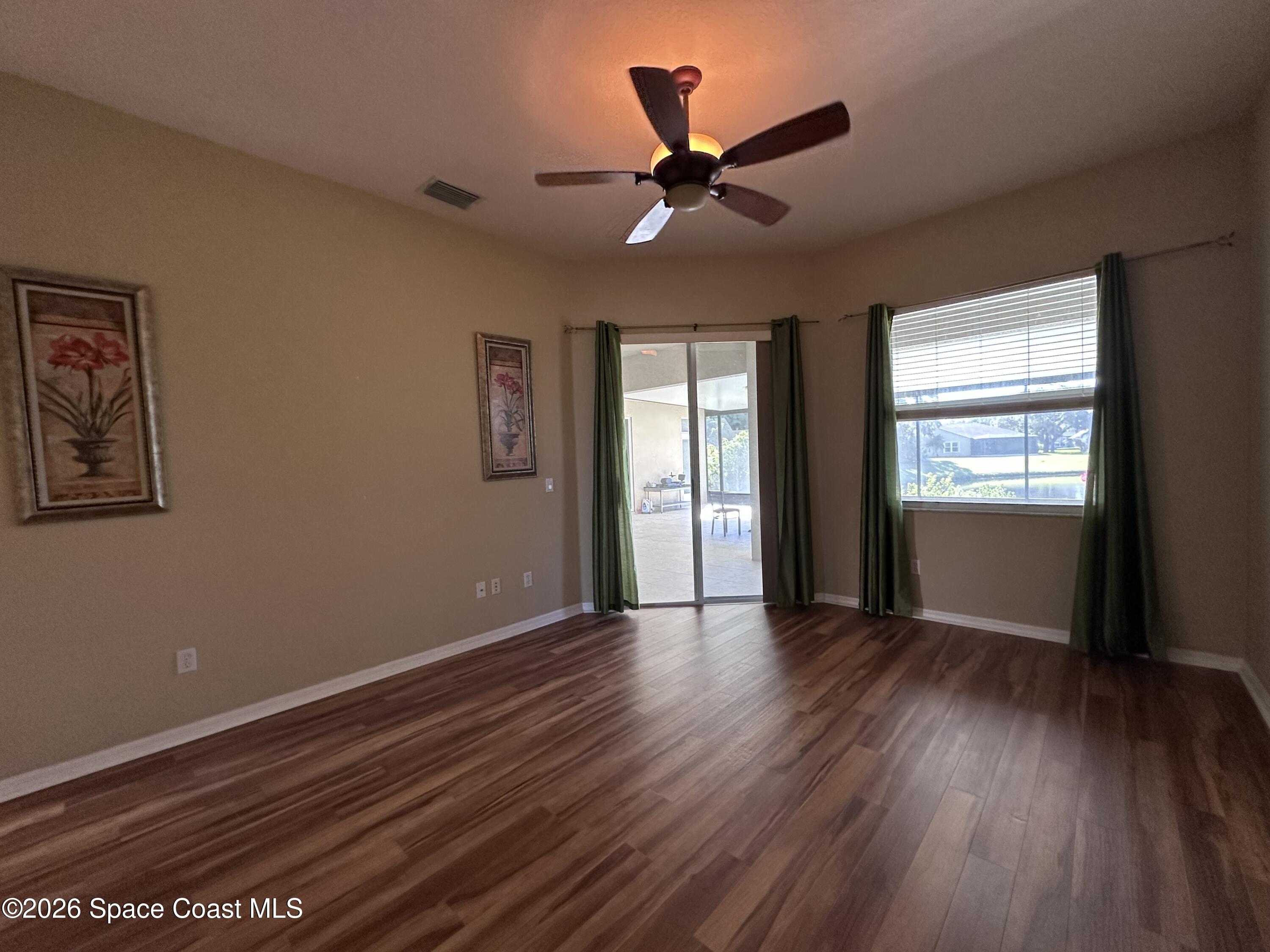 883 Spring Oak Drive Melbourne, FL 32901 - Photo 6 of 43 a view of an empty room with window and wooden floor