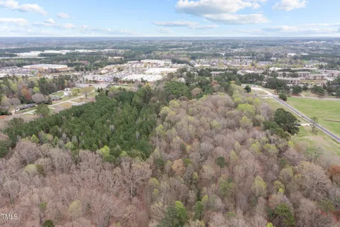 an aerial view of residential houses with outdoor space and trees