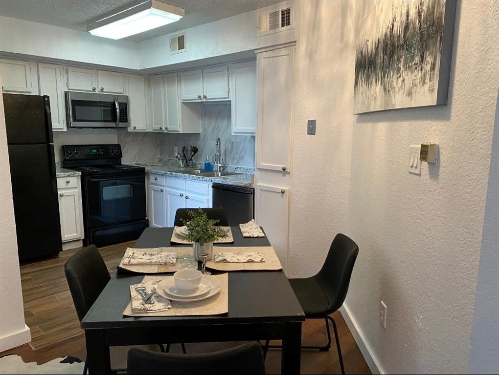 a kitchen with a table chairs and a refrigerator