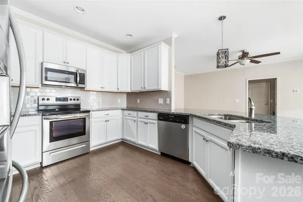 a kitchen with stainless steel appliances granite countertop a stove sink and cabinets