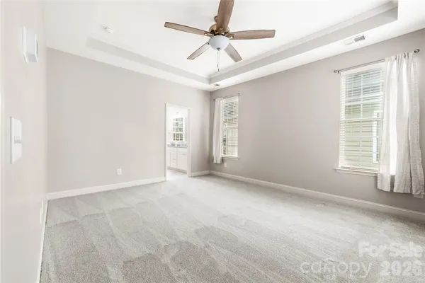 an empty room with windows and fan