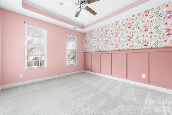 an empty room with a ceiling fan and window