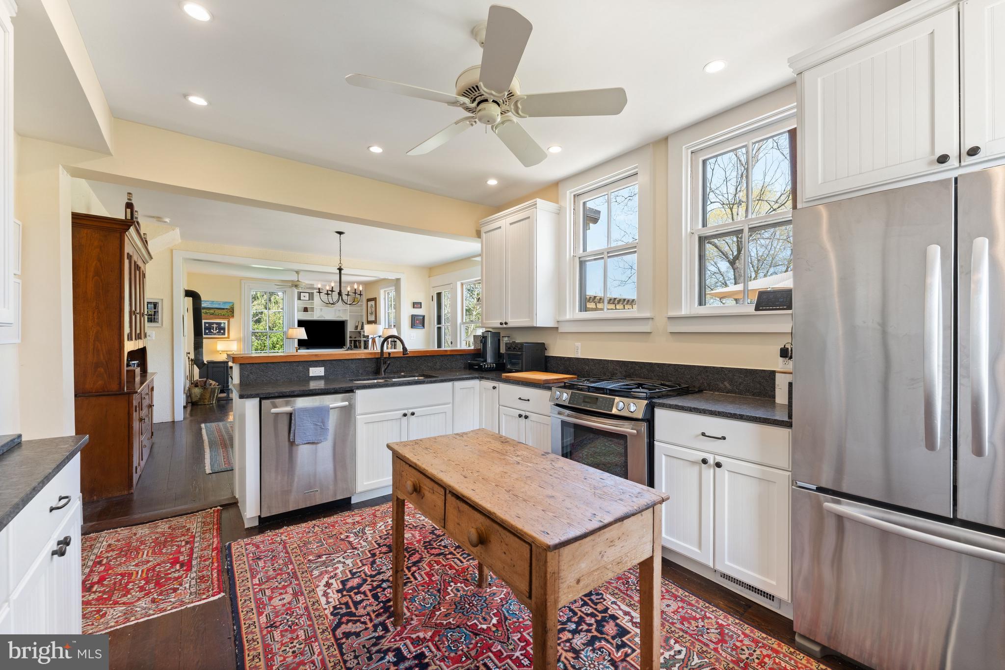 3459 Carrington Road Delaplane, VA 20144 - Photo 15 of 106 a kitchen with stainless steel appliances granite countertop a refrigerator a stove a sink a dining table and chairs with wooden floor