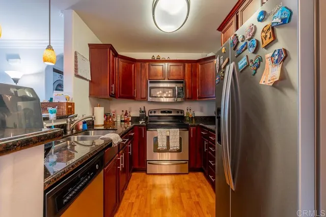 a kitchen with stainless steel appliances granite countertop a stove a sink and a microwave