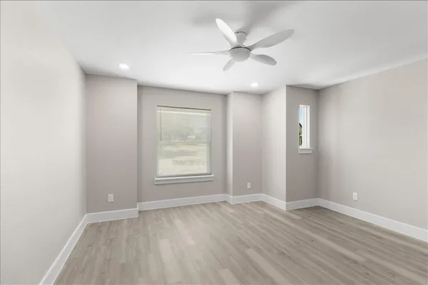 an empty room with a window and wooden floor