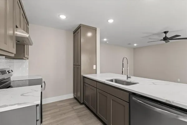 an empty room with wooden floor ceiling fan and windows