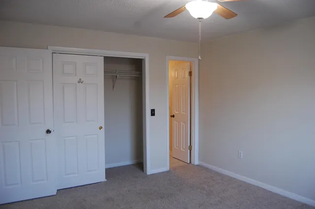 a view of an empty room with a ceiling fan