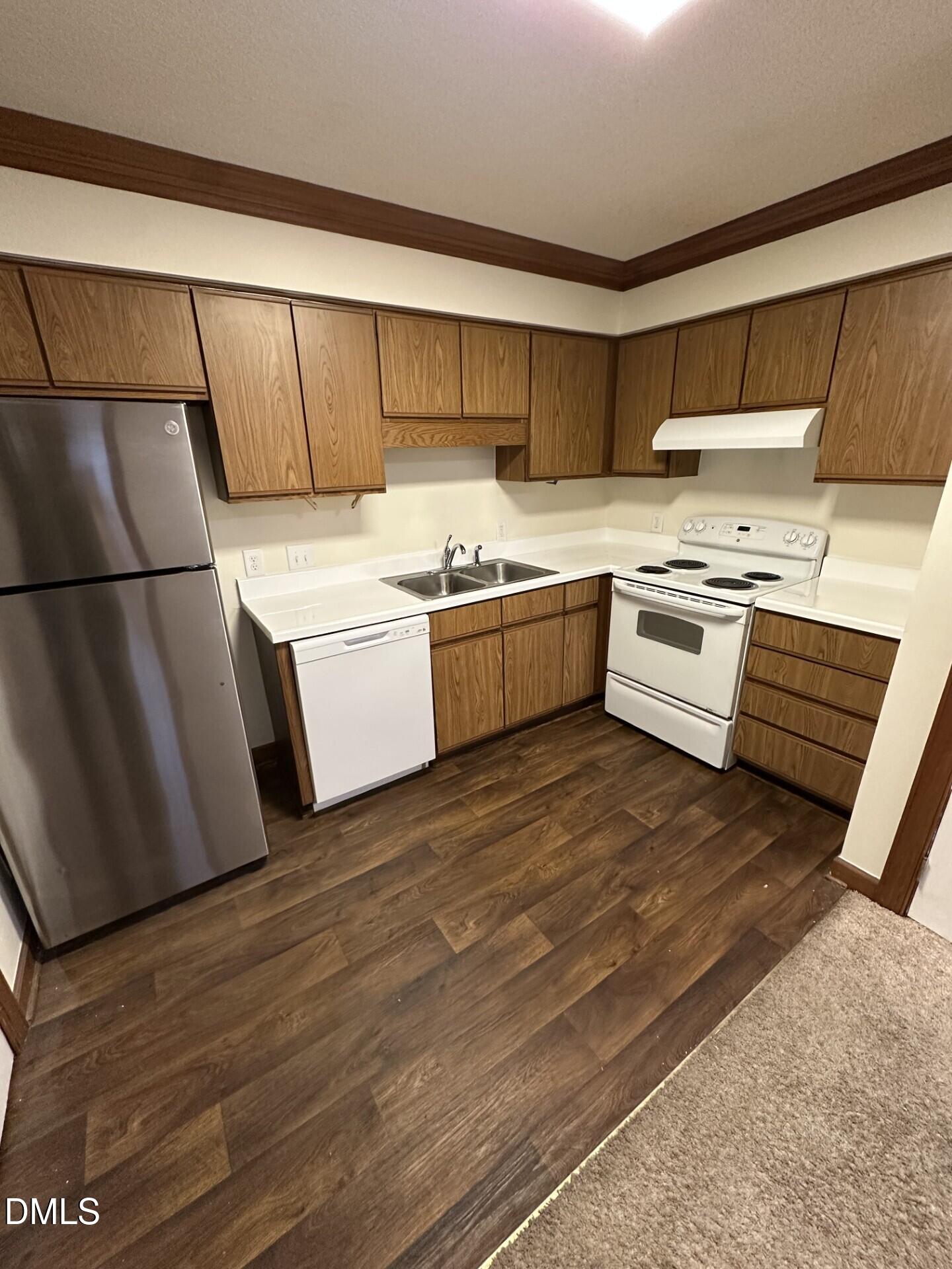 3535 Ivy Commons Drive, Unit 302 Raleigh, NC 27606 - Photo 4 of 9 a kitchen with stainless steel appliances a stove a sink and white cabinets