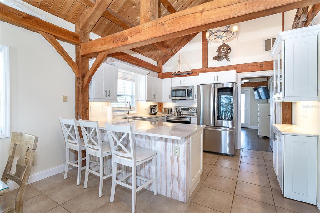 360 South Gulf Boulevard Boca Grande, FL 33921 - Photo 11 of 64 a kitchen with stainless steel appliances granite countertop a table chairs and a refrigerator