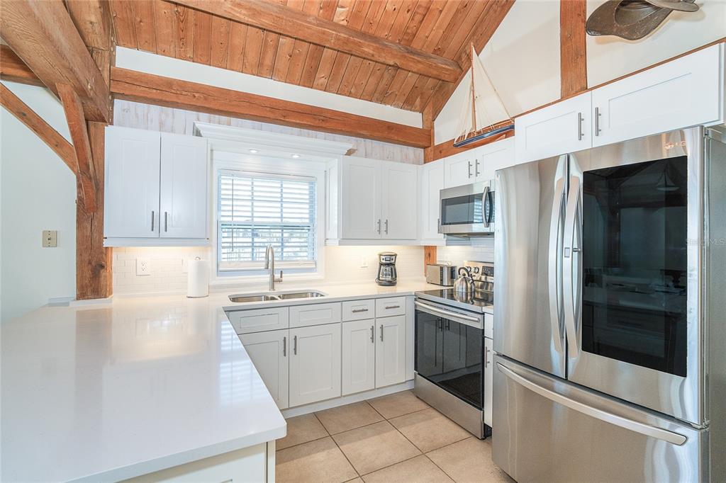 360 South Gulf Boulevard Boca Grande, FL 33921 - Photo 14 of 64 a kitchen with a sink stainless steel appliances and cabinets