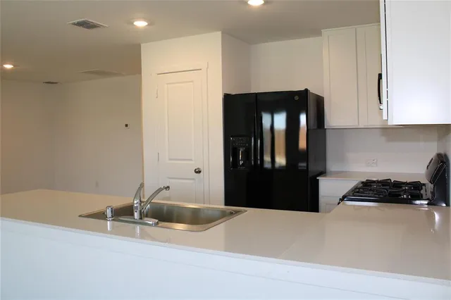 a kitchen with a refrigerator and a sink