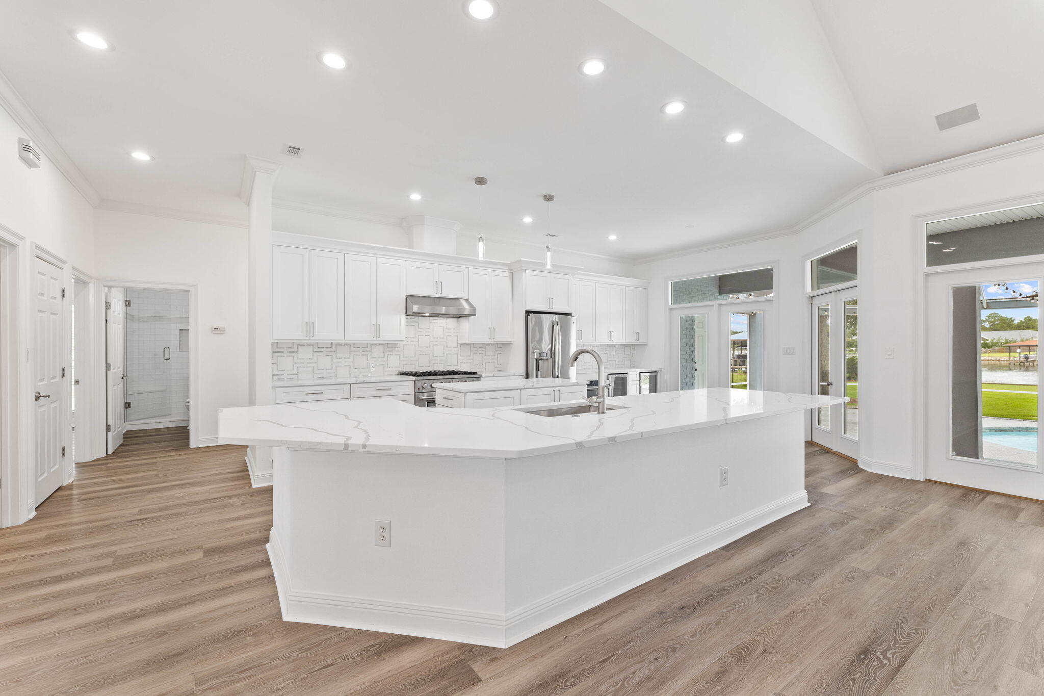 1780 Driftwood Point Road Santa Rosa Beach, FL 32459 - Photo 80 of 101 a large white kitchen with kitchen island a sink a center island stainless steel appliances and a counter top space