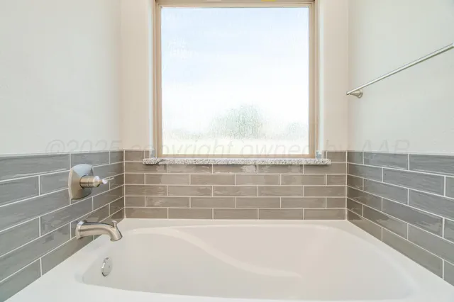 a bathroom with bathtub and window