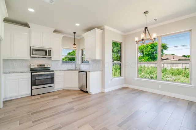 a kitchen with kitchen island a counter top space appliances and cabinets