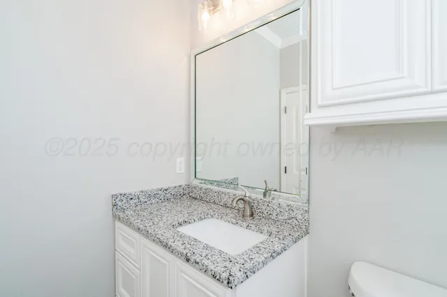 a bathroom with a granite countertop sink and a mirror