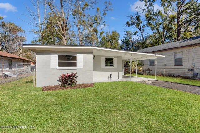 a view of a house with backyard and porch