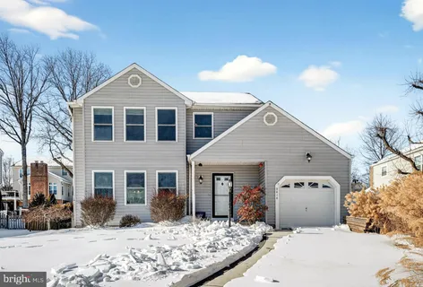 a front view of a house with a yard covered in snow