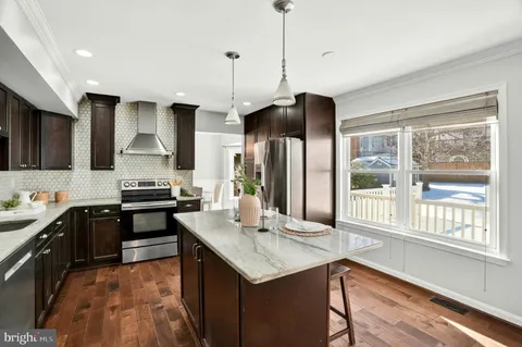 a kitchen with stainless steel appliances granite countertop a sink a stove and a refrigerator