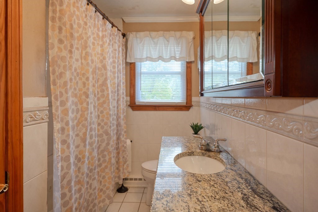 14 Princeton Road Burlington, MA 01803 - Photo 17 of 40 a bathroom with a granite countertop sink and a mirror