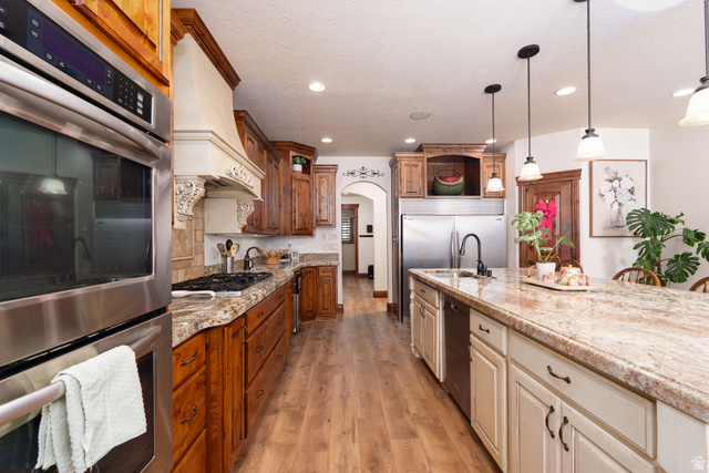 687 South 2080th Street East Springville, UT 84663 - Photo 5 of 149 Gourmet kitchen with stainless steel appliances, a built-in oven, a gas cooktop, a custom vent hood, and a large central island with pendant lighting